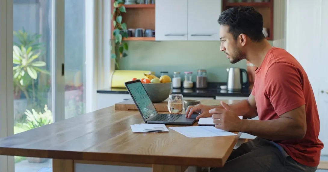 Person sitting at a table while looking at a computer
Person sitting at a table while looking at a computer