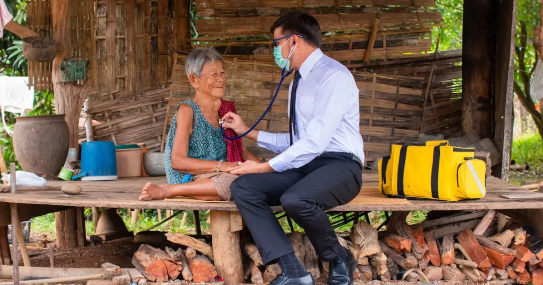 A rural doctor checking an elderly person's breathing with a stethoscope in a hut
A rural doctor checking an elderly person's breathing with a stethoscope in a hut