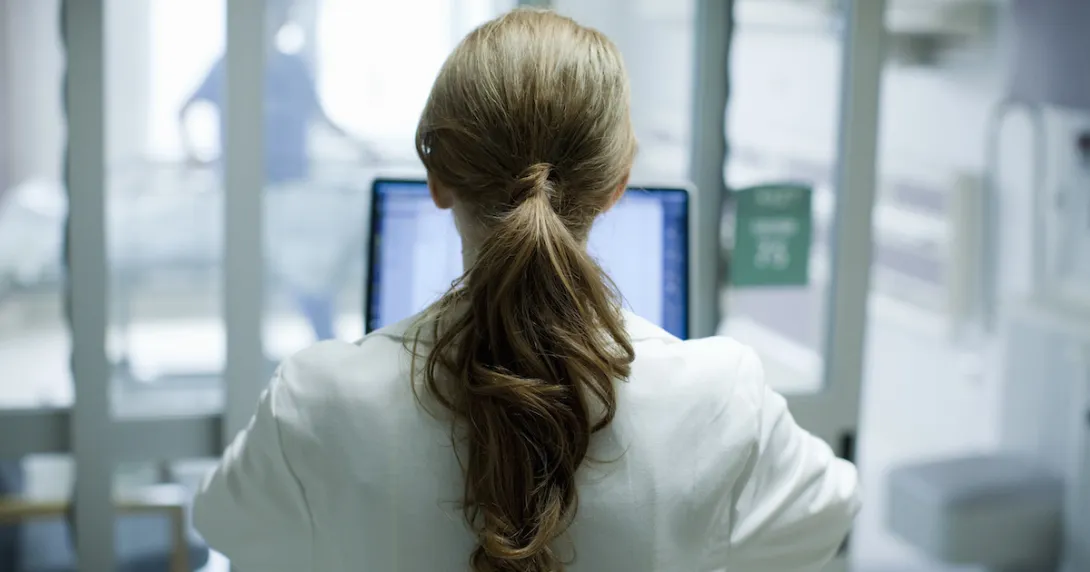 Healthcare provider standing with their back facing the camera in a clinic