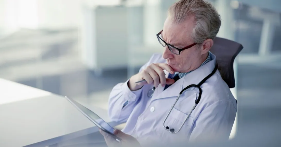 Healthcare provider sitting at a desk and looking at a chart
