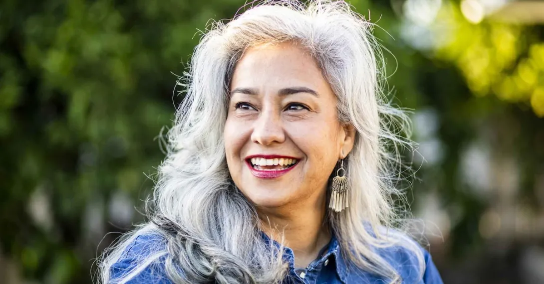 Portrait of a gray haired individual smiling