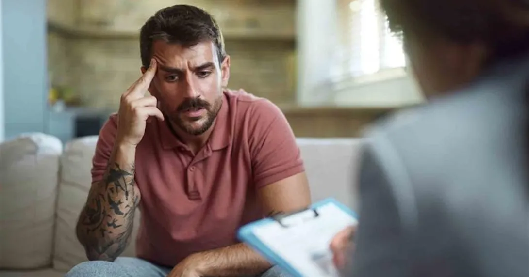 Person who looks upset sitting with a therapist