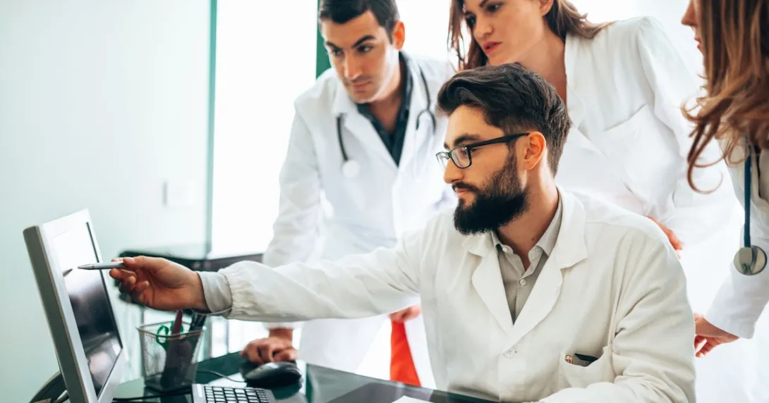 Four healthcare providers looking at a computer