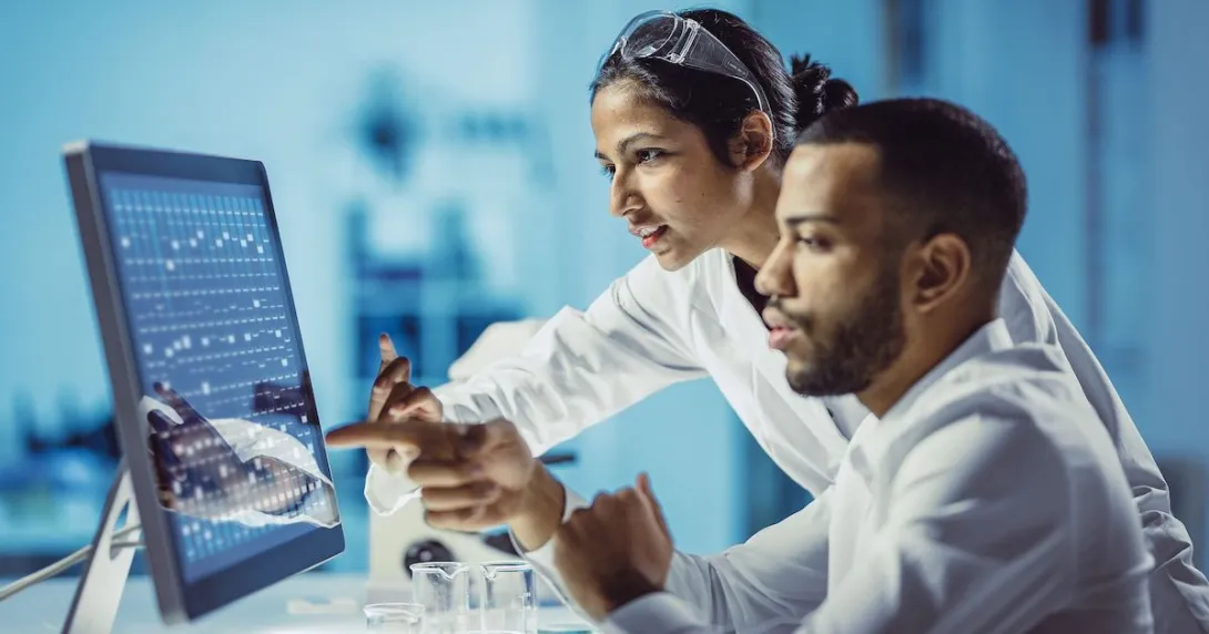 Two scientists sitting at a computer in a laboratory