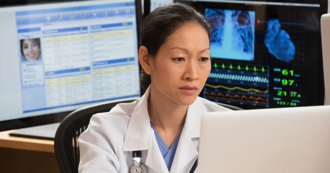 A doctor analysing a report on a desktop computer
