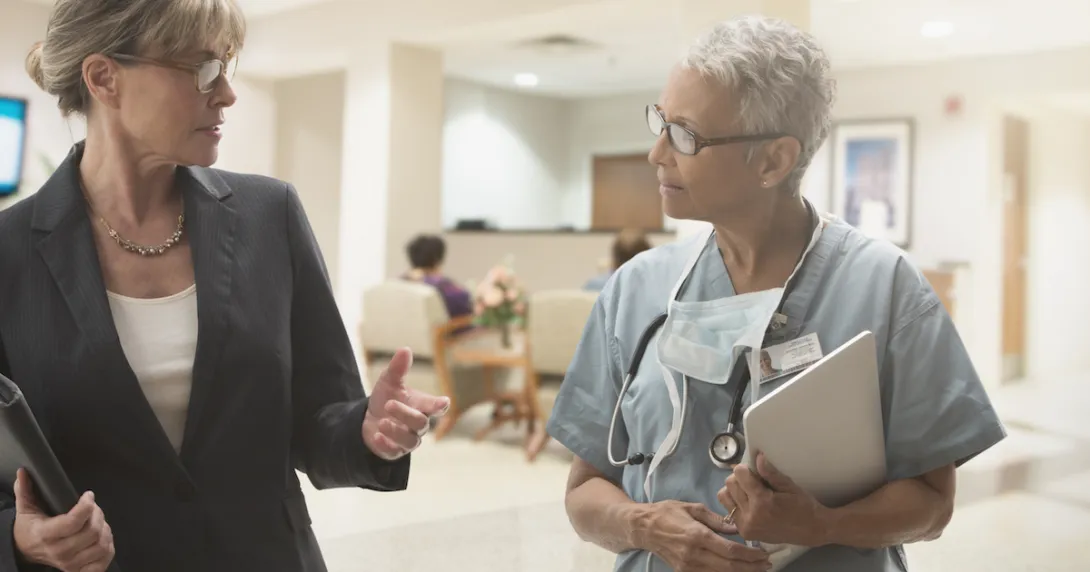 Healthcare provider and another person walking through a care center