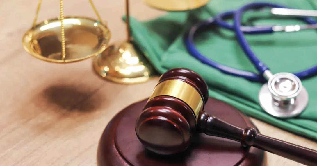 A gavel next to a scale and a stethoscope