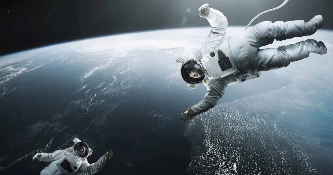 Two astronauts floating in space with the Earth behind them