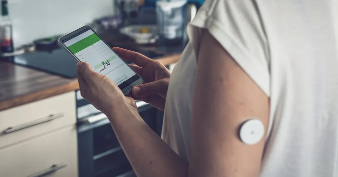 A patient checks their blood glucose level through a smartphone app