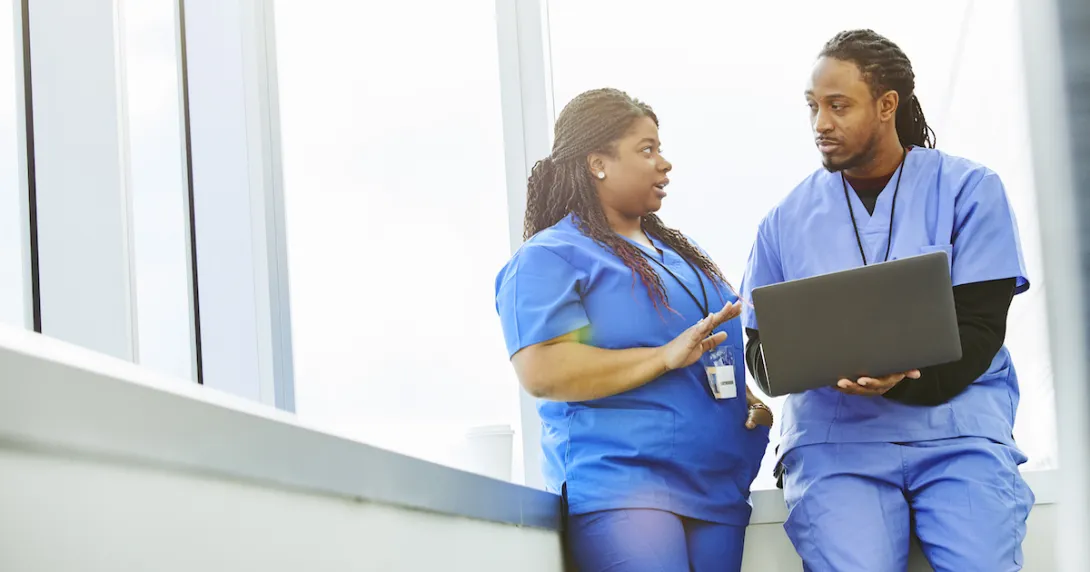 Healthcare providers sitting in by a window while looking at a computer