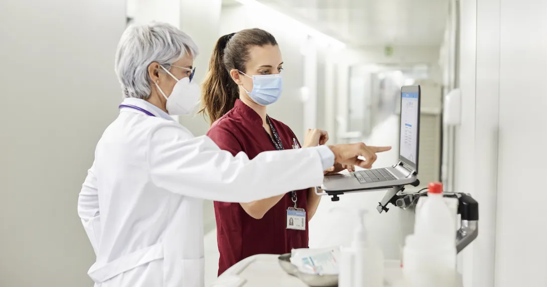 Healthcare professionals standing at a computer