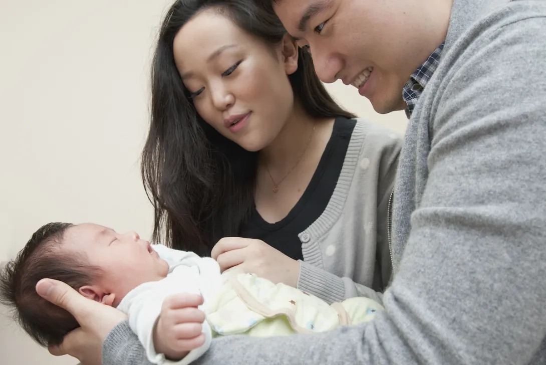 Two people holding another person while standing over them