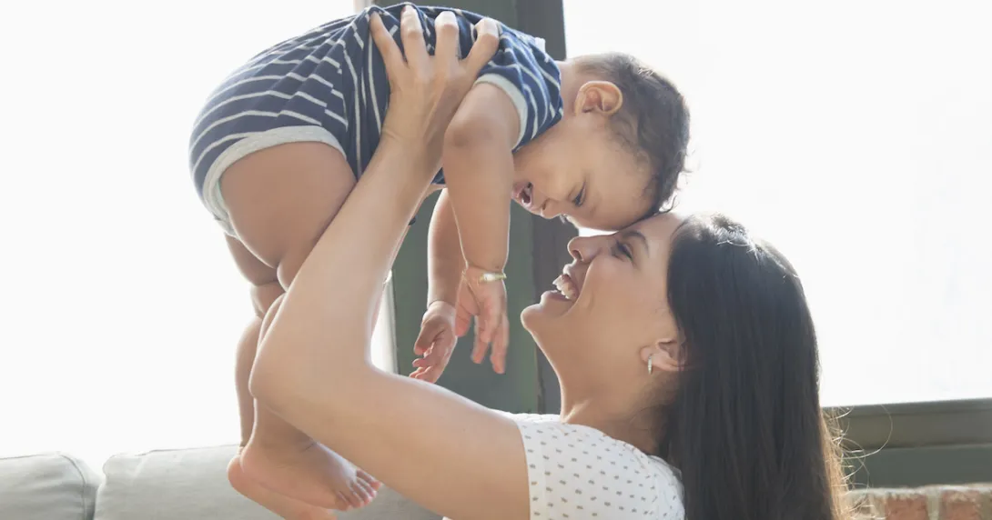 Person holding another person while both are smiling
