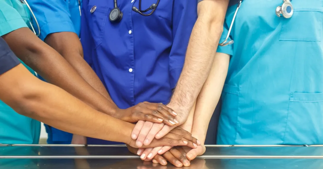Healthcare providers putting their hands together