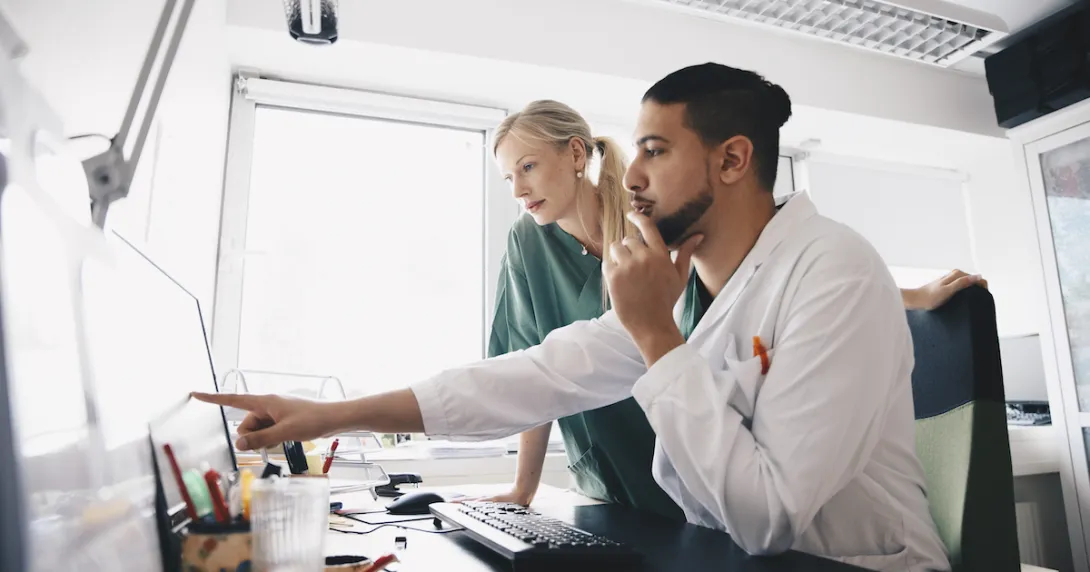 Healthcare professionals examining computer screen.