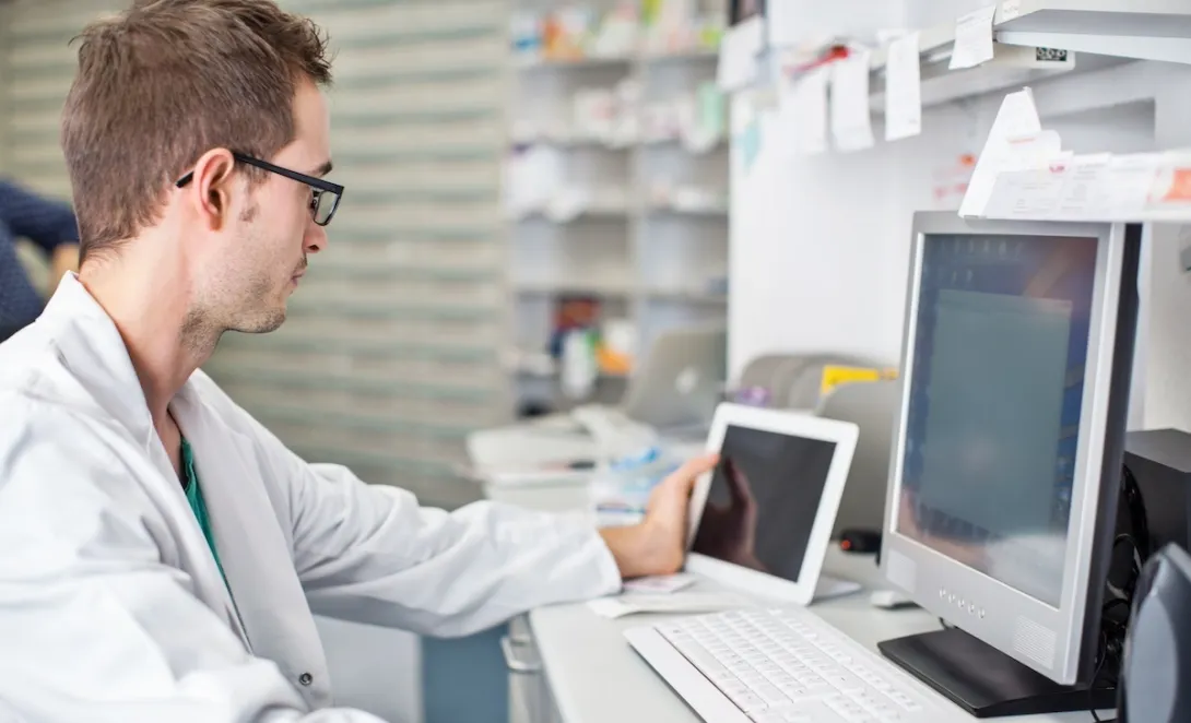 Clinician looking at data on a smart pad  tablet and computer screen