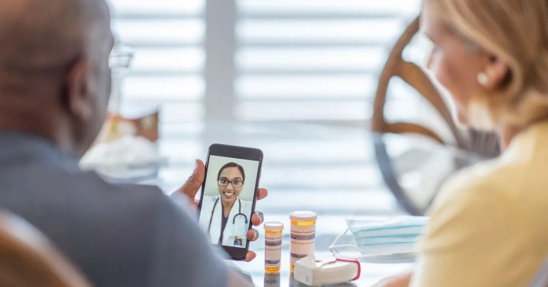 A couple talking to a provider through a video chat on a smartphone.