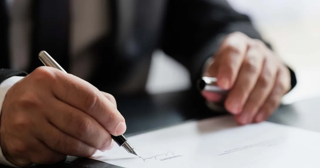 Business person signing a document