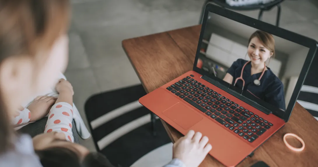 Person looking at a computer with a telehealth provider on the screen