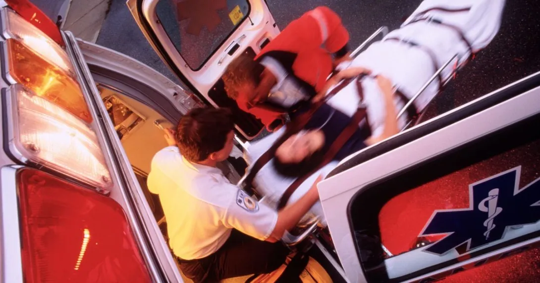 Paramedics loading a patient onto an ambulance