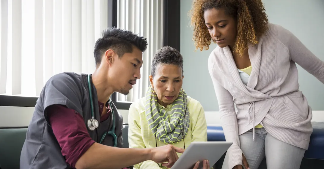 A provider showing a patient and their family member information on a tablet