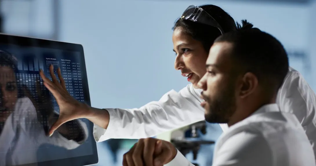 Doctors looking at patient data on a monitor