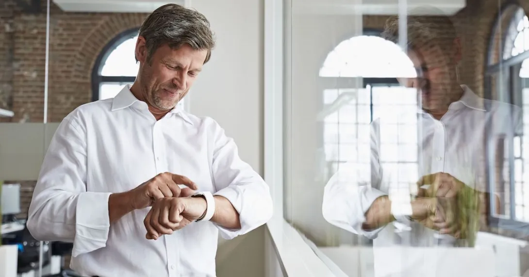 A man in an office wearing a smartwatch
