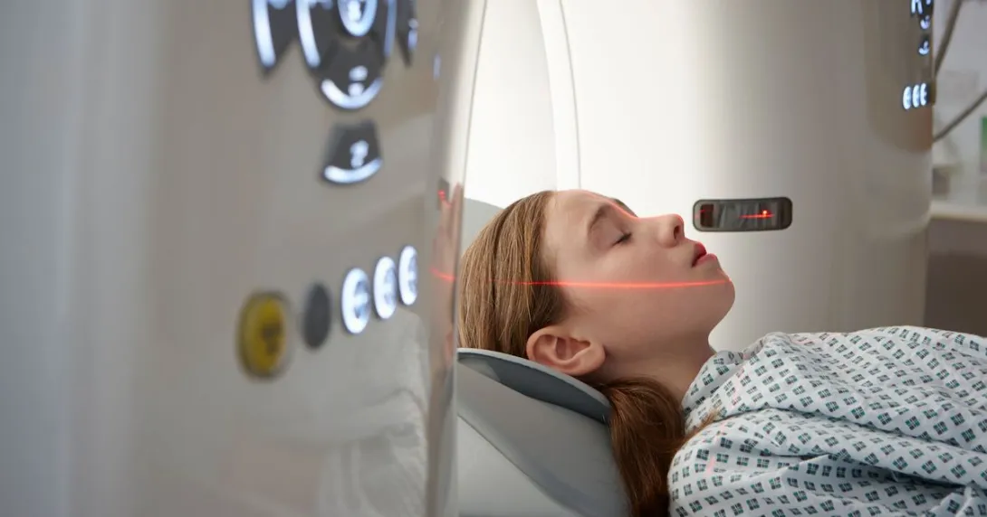 Person being drawn into a diagnostic imaging machine while wearing a hospital gown