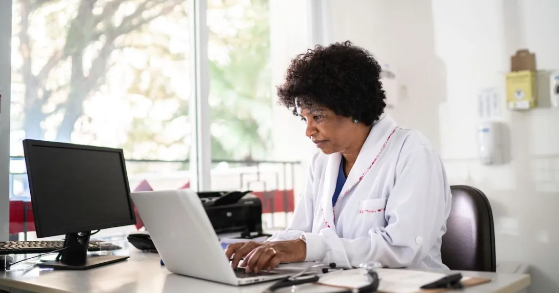 Healthcare provider sitting in an office at a desk with a computer on it