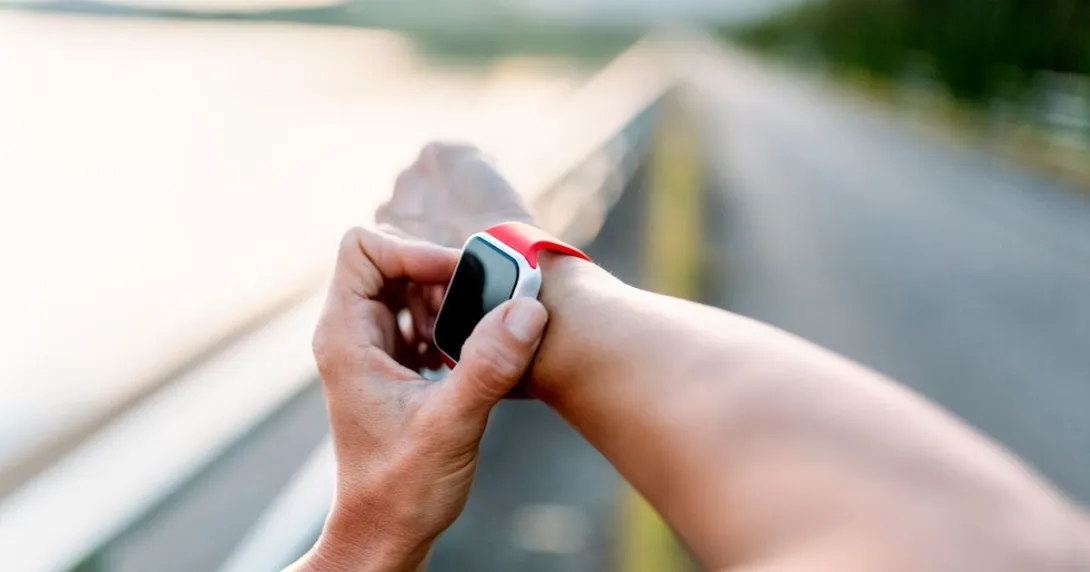 Person's arms with one hand playing with an Apple Watch