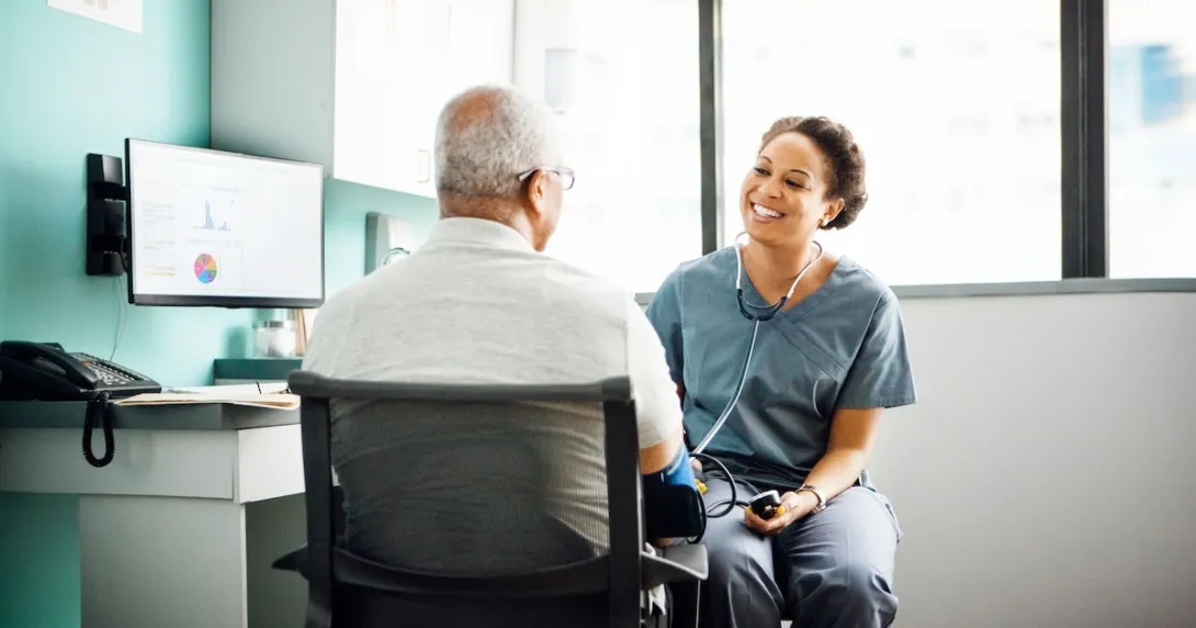 Healthcare provider sitting next to a patient in the clinical setting