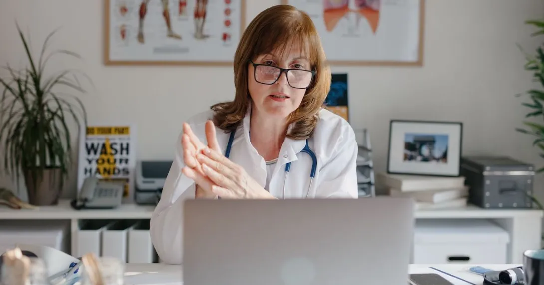 A doctor using a laptop for a virtual consultation
