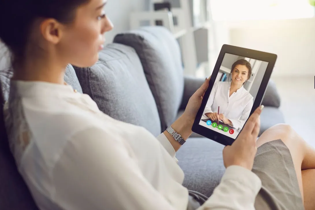 A woman talking to a provider on a tablet