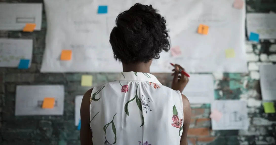 Person looks at plans posted on office wall
